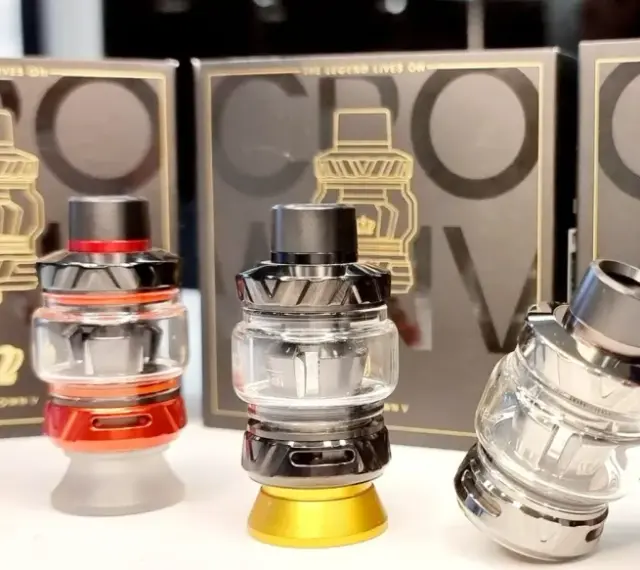 Tres atomizadores Uwell Crown V en rojo, negro y plateado, con sus cajas de fondo.